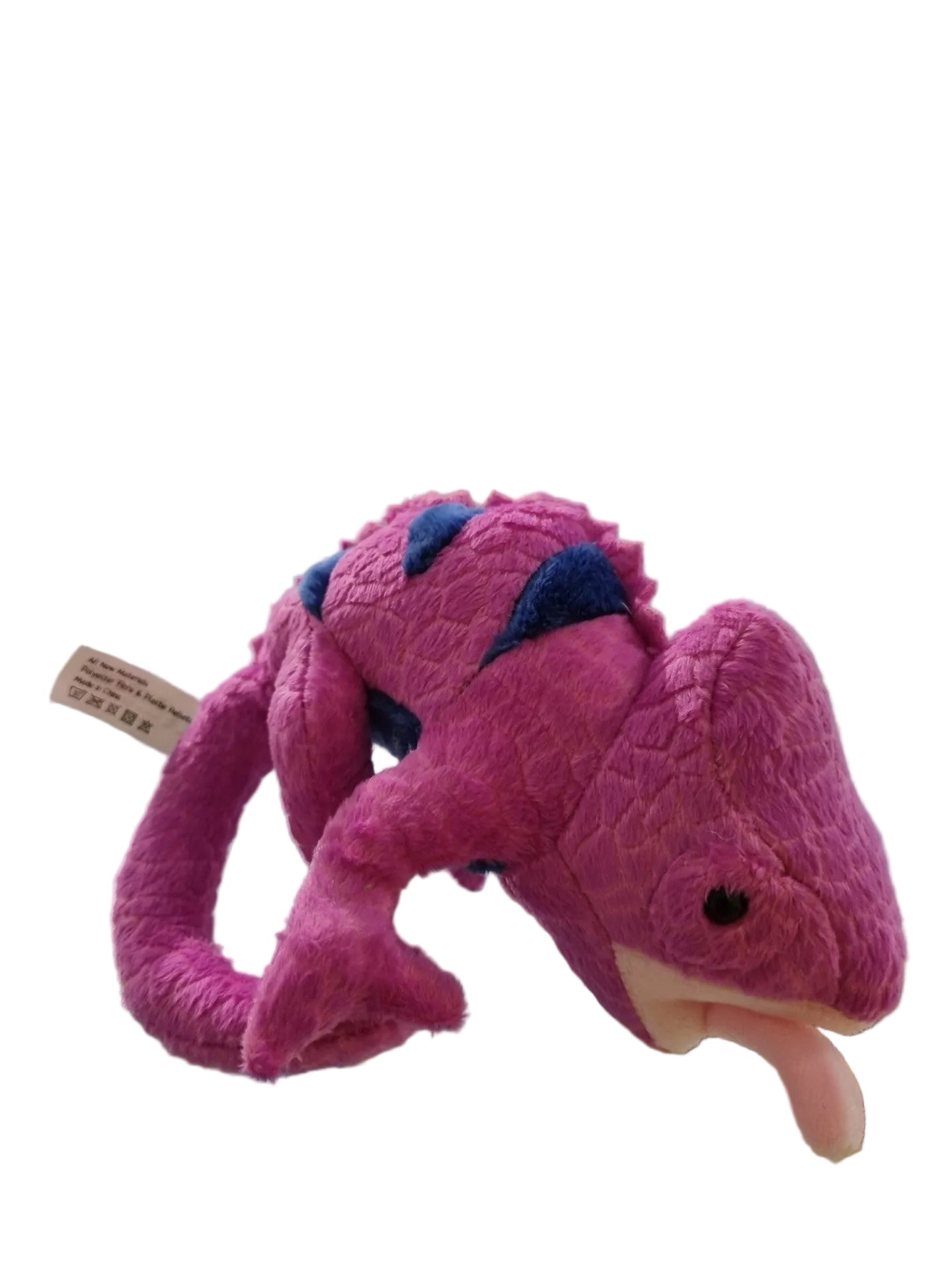 A pink plush chameleon toy with blue accents and a pink tongue, resting on a glass display counter in a toy store.