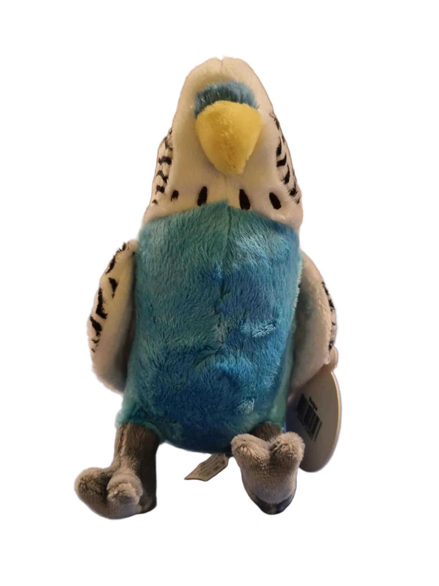 A small bird plush toy with a white head, black-and-white striped wings, a bright blue body, and a yellow beak, sitting on a blue surface in a store setting.