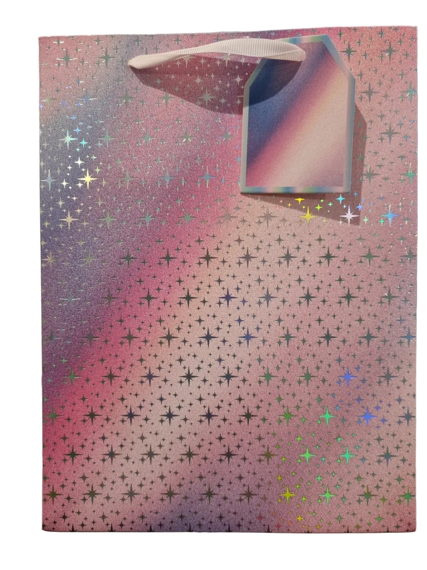 A pink holographic gift bag with a gradient of purple and blue, covered in small star patterns and featuring a white ribbon handle.