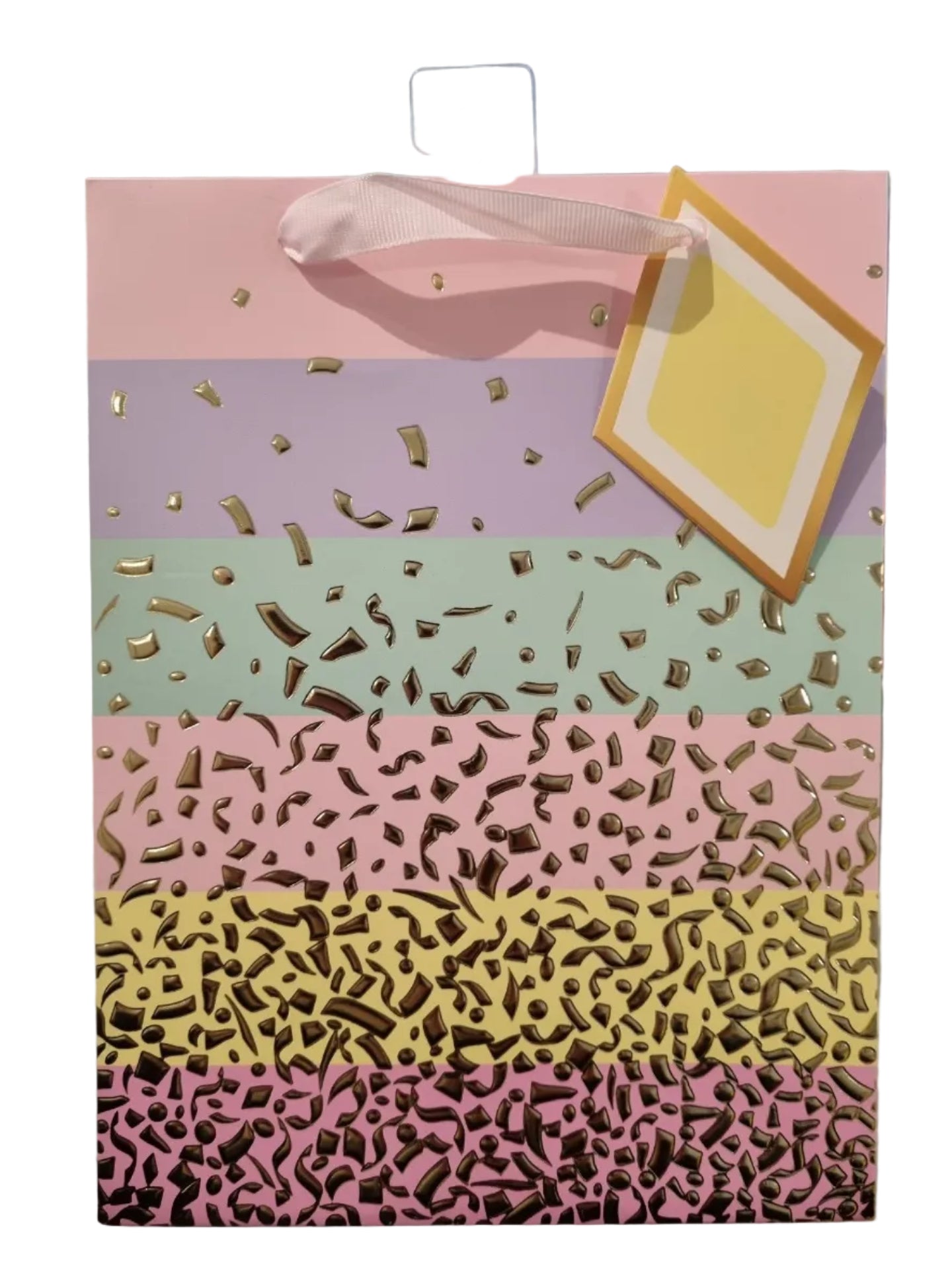 A square gift bag or card with a pastel striped design in pink, yellow, mint green, lavender, and light pink, decorated with metallic gold confetti. A white ribbon loop and a blank yellow gift tag are attached on the right side.