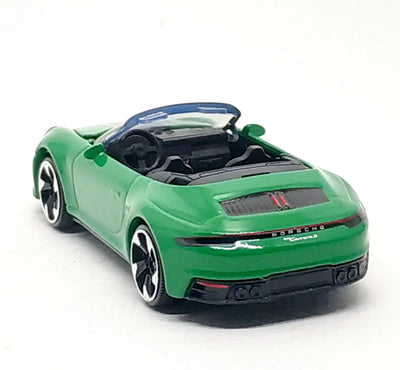 A green Porsche 911 Carrera S diecast model car with a black convertible top and silver multi-spoke wheels, photographed on a white background.