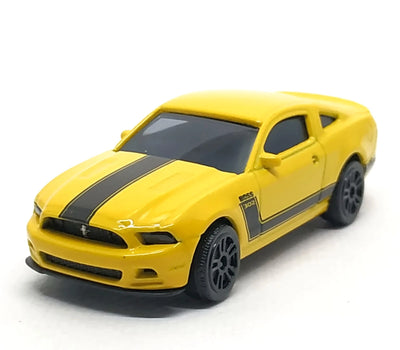 A yellow die-cast model car of a Ford Mustang Shelby GT with black racing stripes, shown on a plain white background.