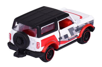 A die-cast toy SUV resembling a Ford Bronco, featuring a white body with red and gray graphic decals, a black roof, and a black spare tire mounted on the rear door, set against a plain white background.